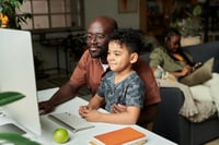 Gostudent vs Acadomia - un pere et un fils cherchant un site de cours particuliers devant un ordinateur