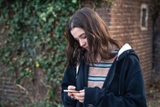 Teenager looking at her phone using ai as emotional support