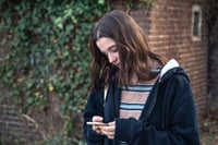 Teenager looking at her phone using ai as emotional support