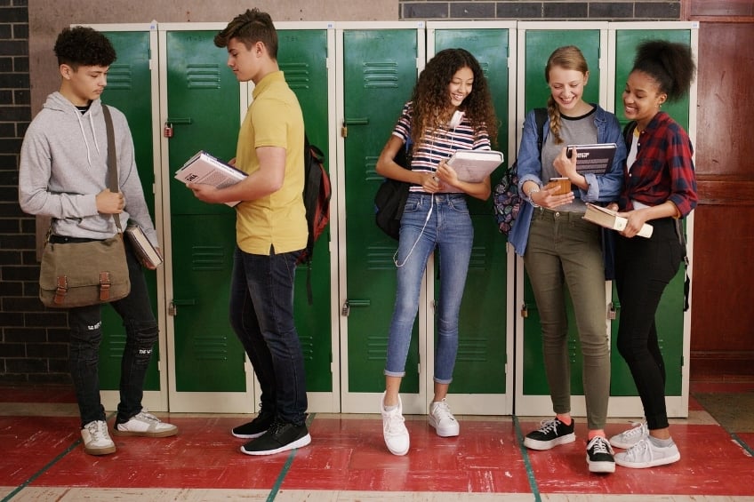 GoStudent - Statistiques Brevet - un groupe de adolescents parlant dans le couloir du  lycee