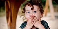 girl with hands over mouth