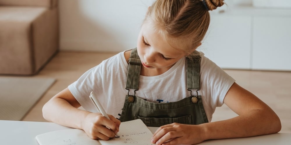 child writing notebook
