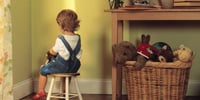 child sitting on stool in bedroom