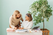 Photo de une professeure particulier donnant un cours de soutien scolaire a son eleve assis sur son bureau