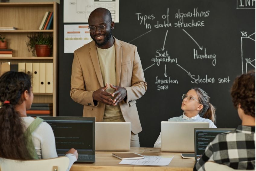 Professeur debout en salle de classe en train de donner son cours