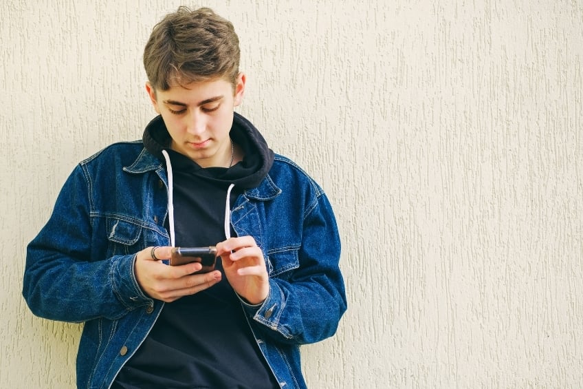 Un adolescent se confiant a une ia sur son smartphone