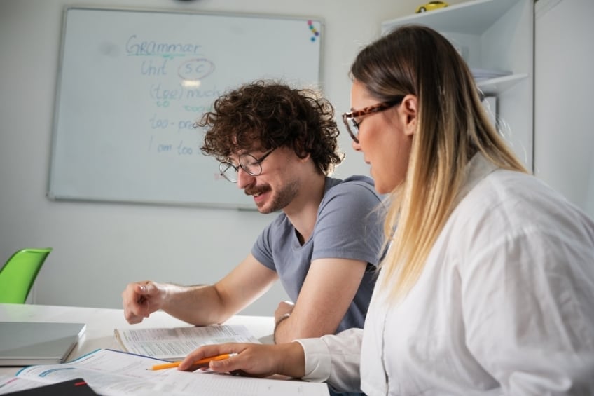 Un eleve jeune adulte et sa professeure particulier en cours de anglais