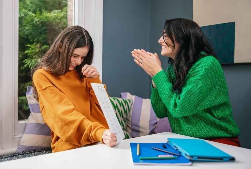 Une mere et sa fille heureuses avec les notes scolaires obtenues grace aux cours particuliers