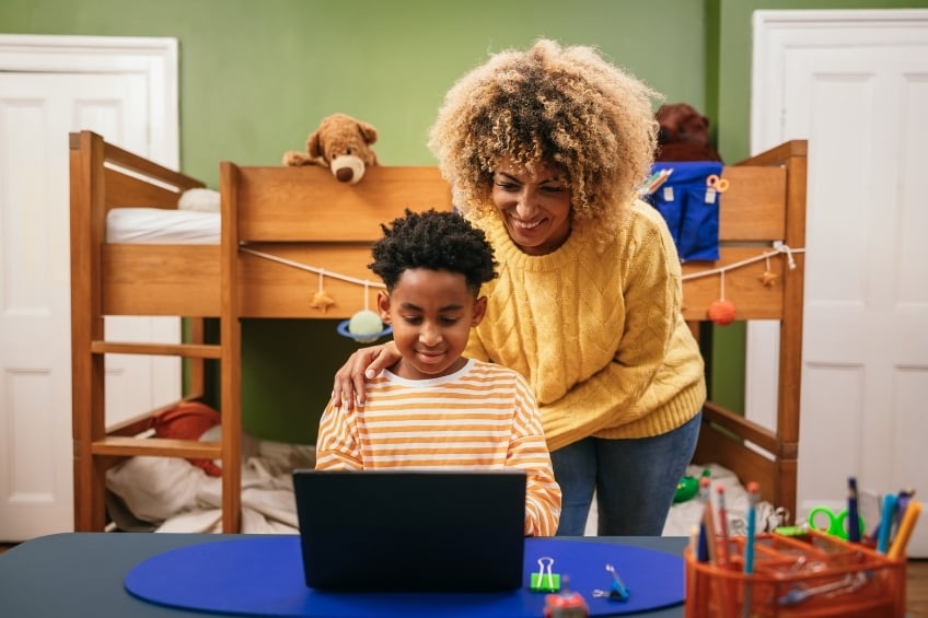 Une mere et son fils cherchant un professeur particulier en ligne pour la rentree
