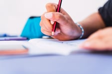 Zoom sur une main redigeant le bac en plein examen