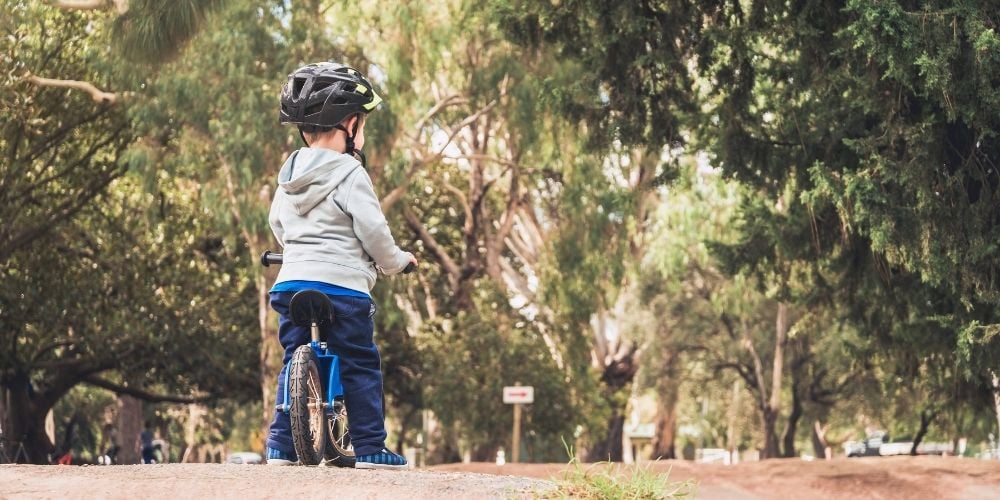 child riding balance bike