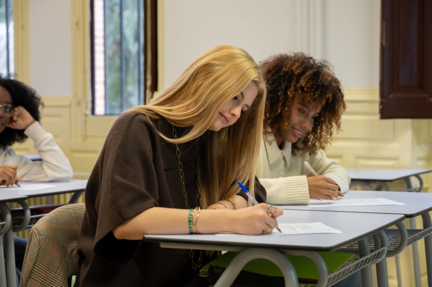 deux eleves assises en train de passer leur examen du TOEFL