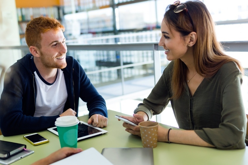 etudiants-discutant-en-anglais-avec-une-tablette-et-cafe-sur-la-table