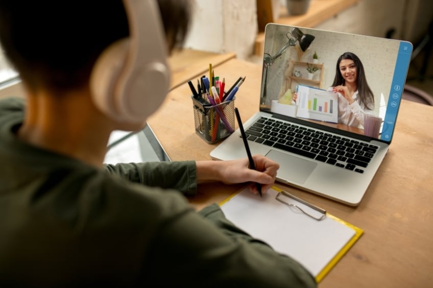 jeune garçon suivant son cours particulier en ligne depuis sa chambre