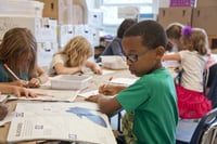 child in classroom reading and writing