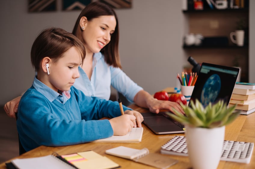 preteen-boy-uses-laptop-to-make-video-call-with-his-teacher-next-to-his-mother