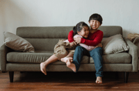 sibling rivalry: kids fighting on a couch