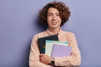smiling-student-holds-notebooks-planning-gcse-resit-strategy