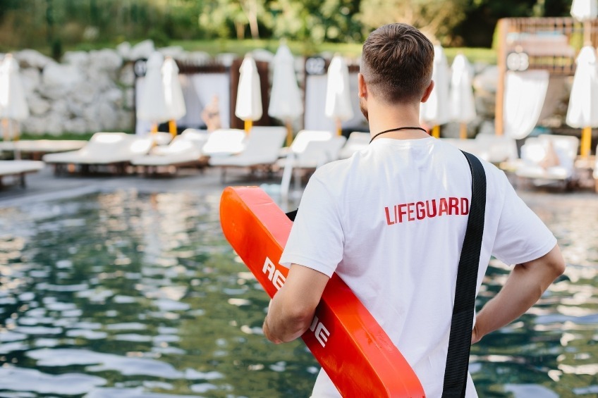 student-summer-job-as-a-lifeguard-holding-a-rescue-tube-by-the-pool