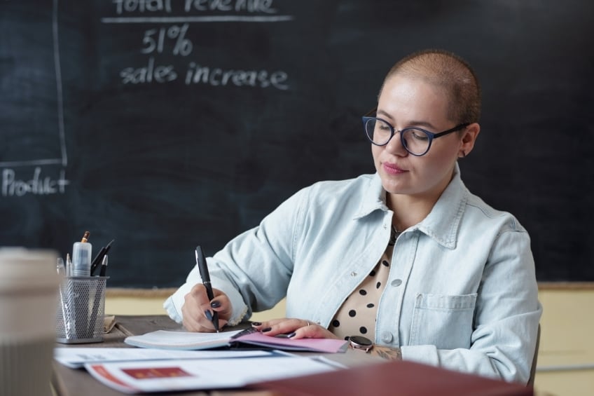 teacher correcting exam papers as a side job for summer