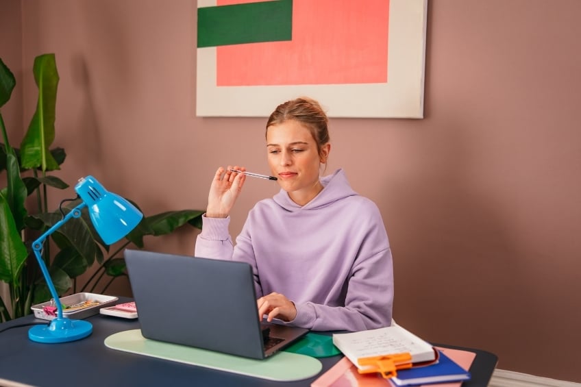 teenage girl studying on her computer in her room to get good grades