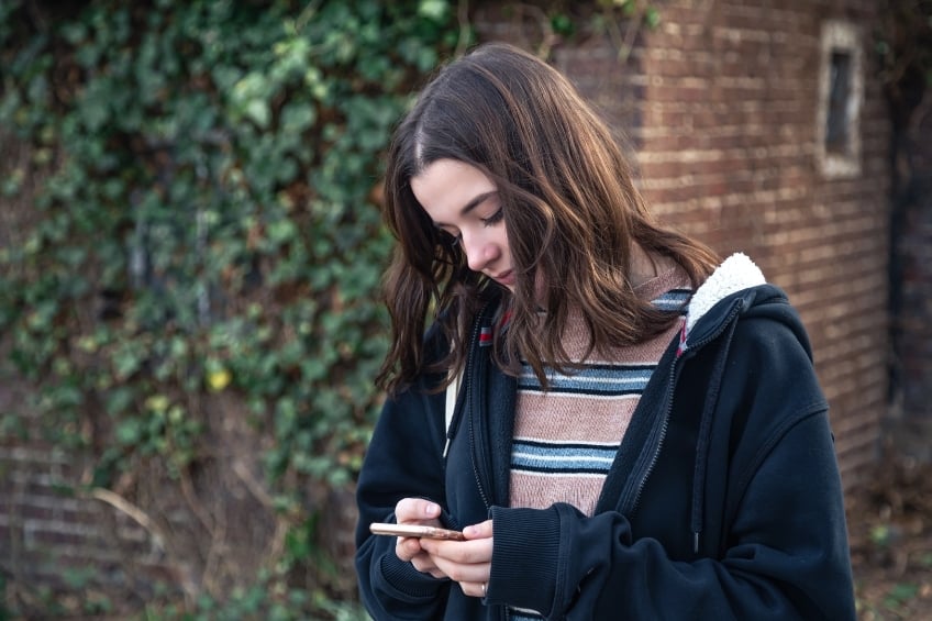 Teenager looking at her phone using ai as emotional support