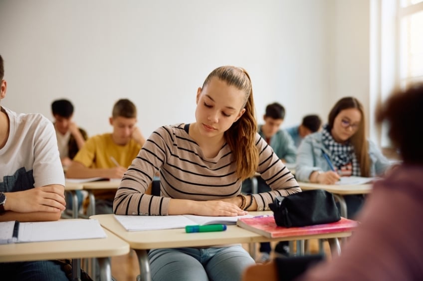 Collegienne assise en train de reviser pour passer le brevet en candidat libre