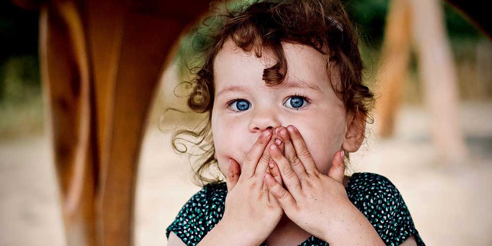 girl with hands over mouth