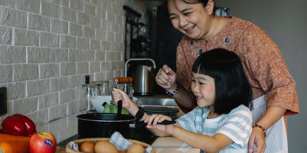kid and parent cooking together in the kitchen