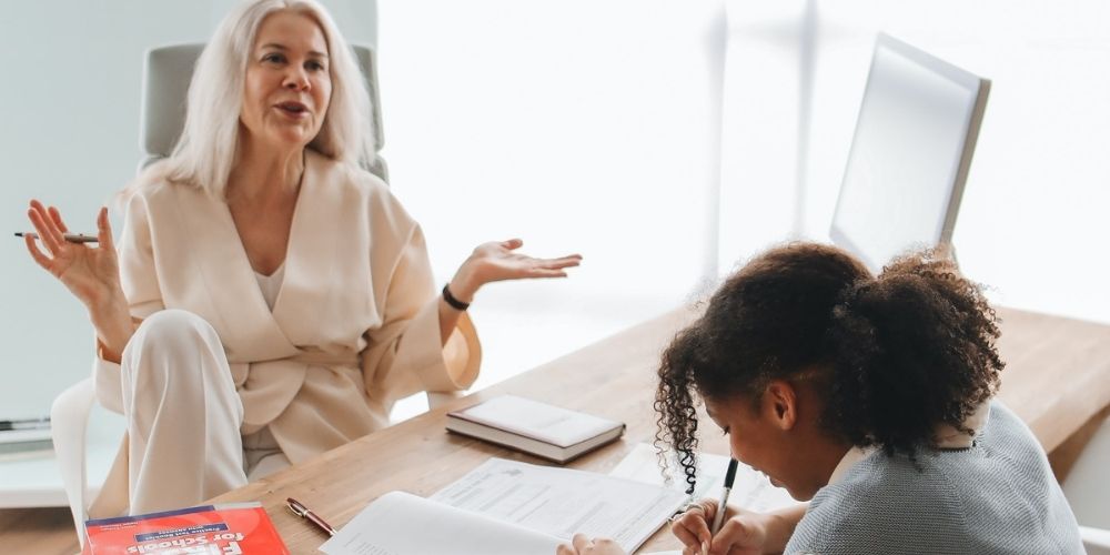 maestra profesora explica a una alumna en una sesión de tutoría