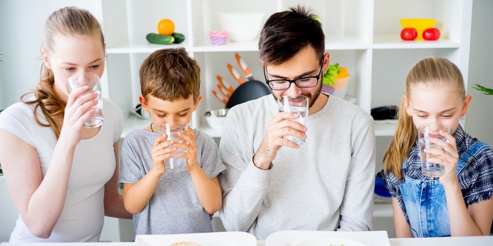importancia-de-beber-agua-familia-bebiendo-vaso-de-agua