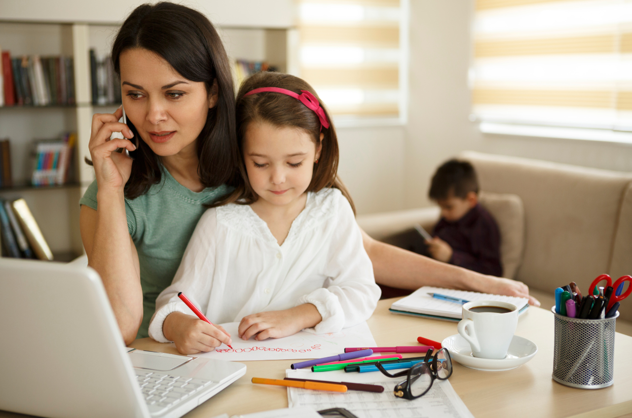mamma lavoratrice che aiuta figli con compiti a casa