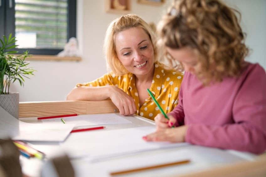 Une professeure particulier et son eleve de primaire en plein cours particulier a domicile