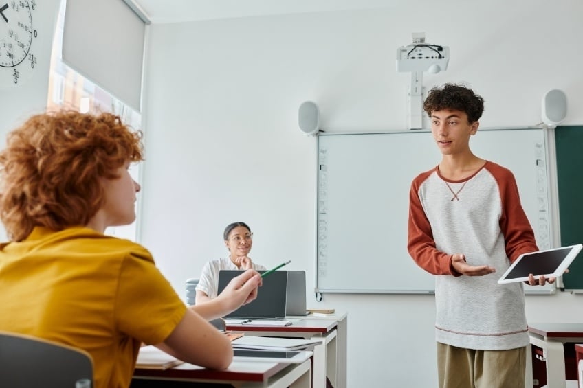 collegien-presente-oral-de-brevet-devant-tableau-et-salle-de-classe