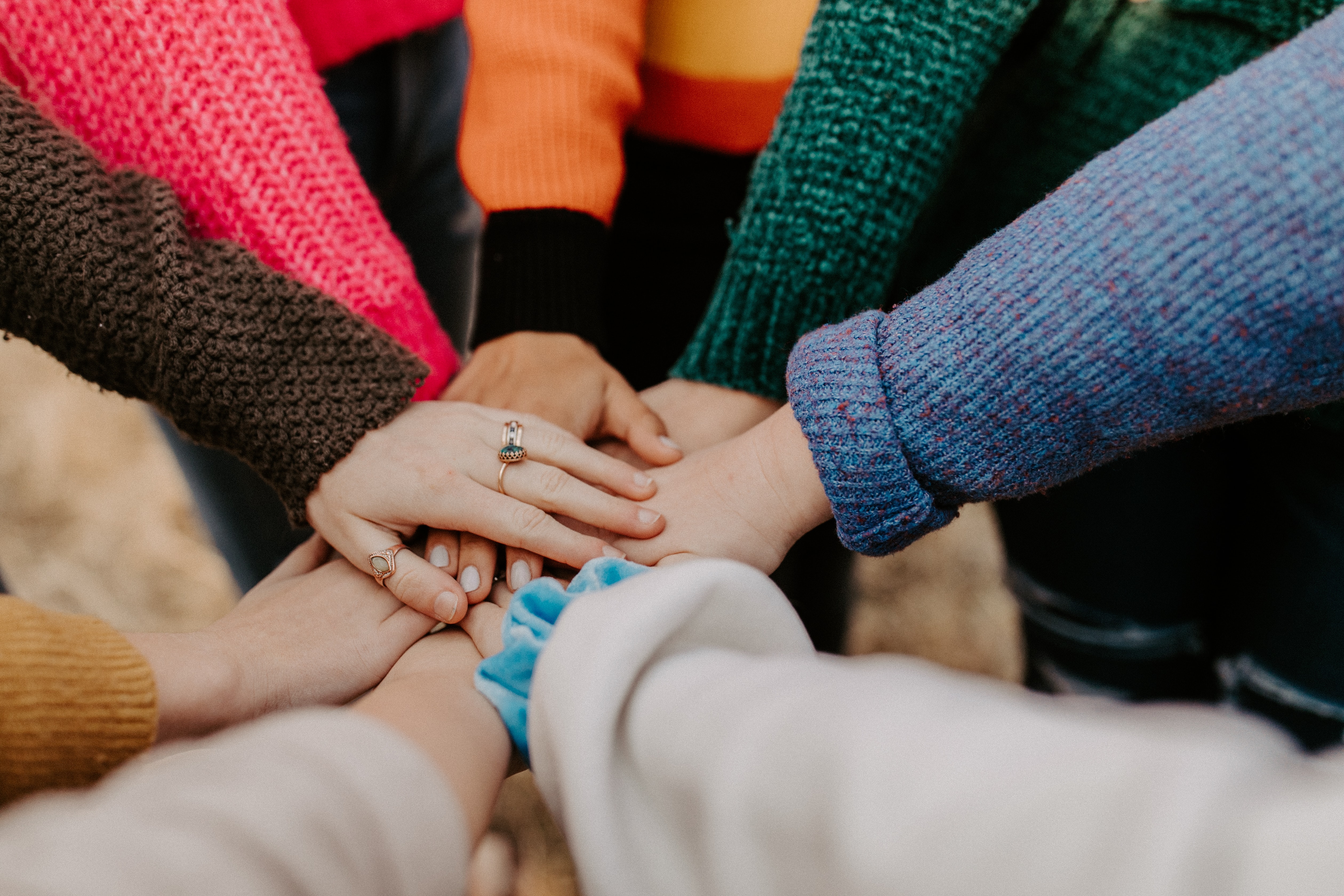 women putting hands together in a circle